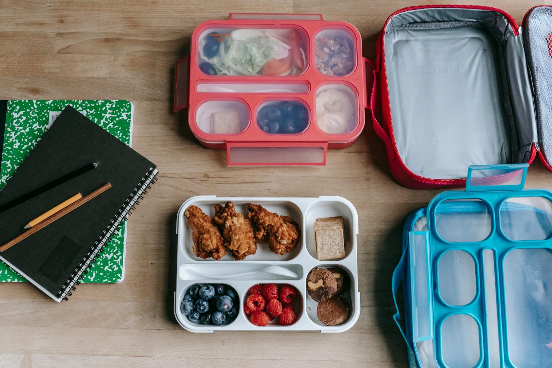 Packed lunch boxes and notebooks on an office table